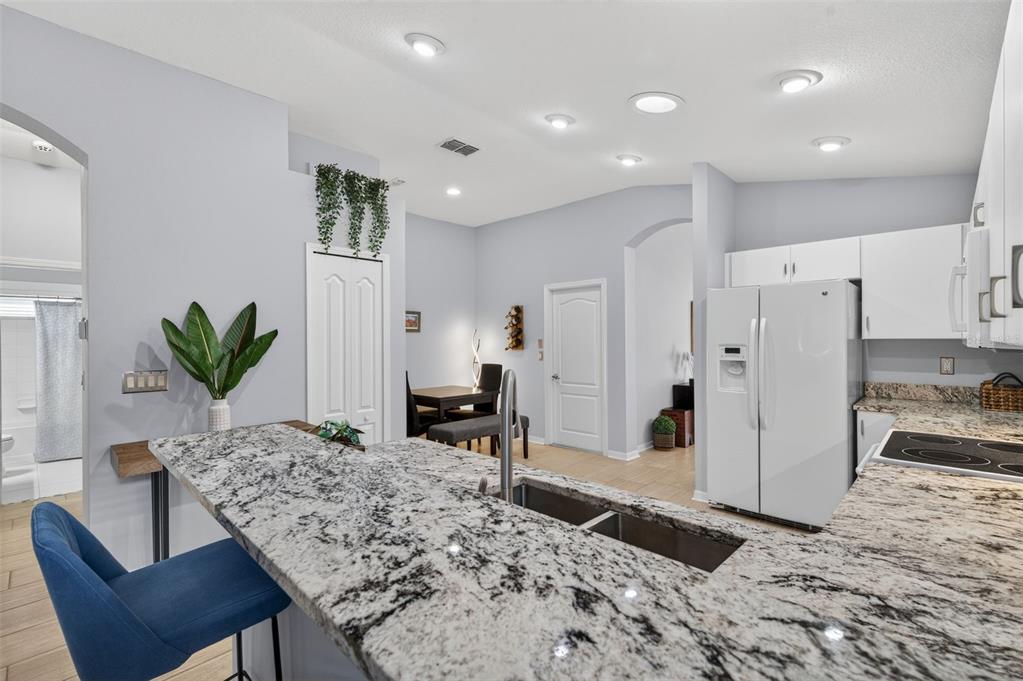 12629 White Bluff Road Hudson, FL 34669 - Photo 7 of 38 a living room with stainless steel appliances kitchen island granite countertop furniture wooden floor and a view of kitchen