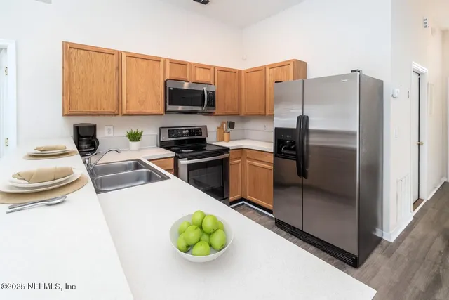 a kitchen with stainless steel appliances a stove refrigerator sink and microwave