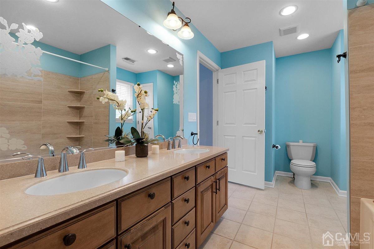 23 Southfield Road Edison, NJ 08820 - Photo 38 of 57 a bathroom with a sink double vanity and a toilet