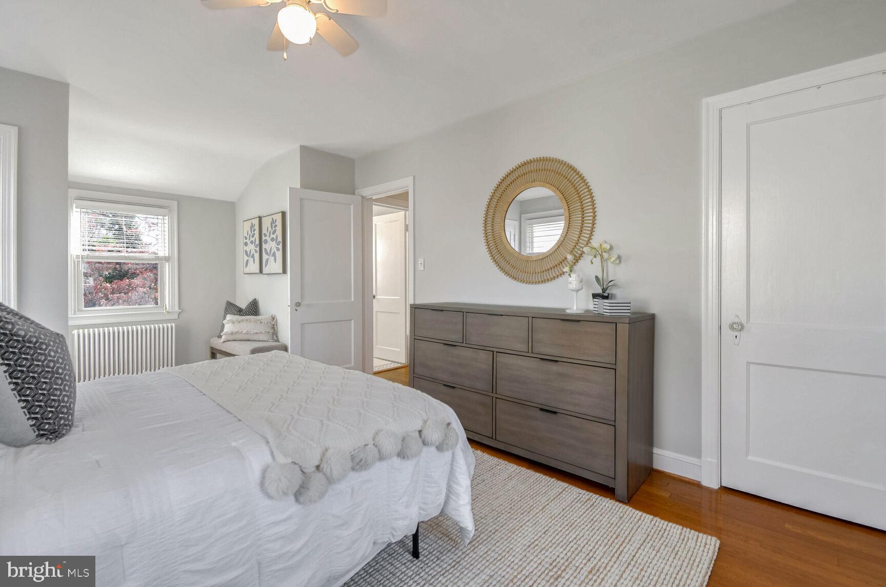 112 St Lawrence Drive Silver Spring, MD 20901 - Photo 12 of 30 a bedroom with a bed a mirror on dresser and a window