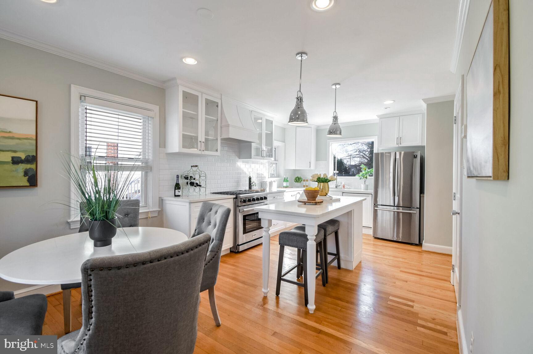 112 St Lawrence Drive Silver Spring, MD 20901 - Photo 6 of 30 a kitchen with stainless steel appliances granite countertop a refrigerator a stove a sink a dining table and chairs with wooden floor