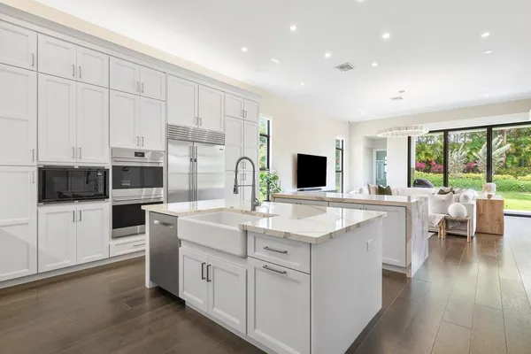 a kitchen with counter top space a sink appliances and cabinets