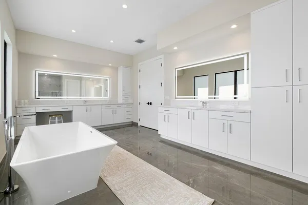 a living room with white cabinets and wooden floor