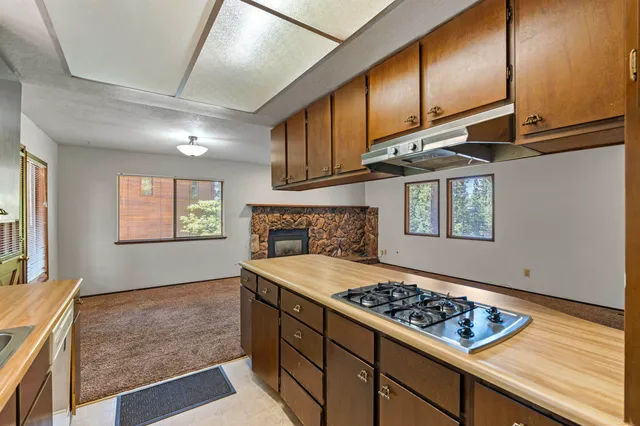 a kitchen with stainless steel appliances granite countertop a stove a sink and a refrigerator