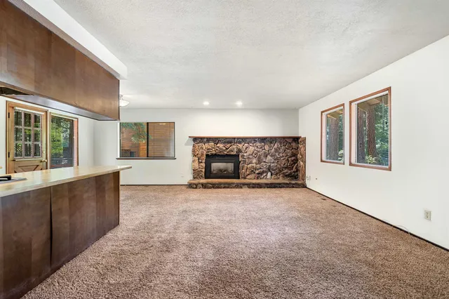 a view of an empty room with a window and fireplace