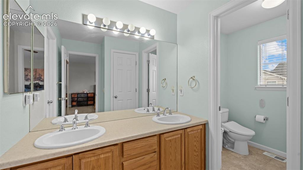 4023 Diamond Ridge View Colorado Springs, CO 80918 - Photo 24 of 31 a bathroom with a sink double vanity and a toilet