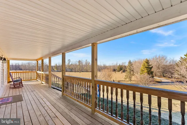 a view of an empty room with window and a ceiling fan