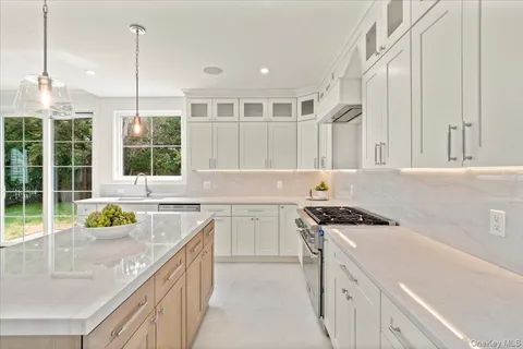 a kitchen that has a sink a stove and a wooden floor