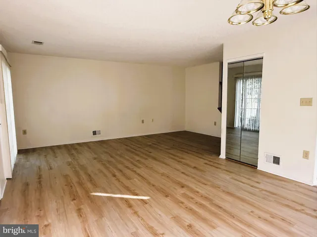 a view of a room with wooden floor and a ceiling fan