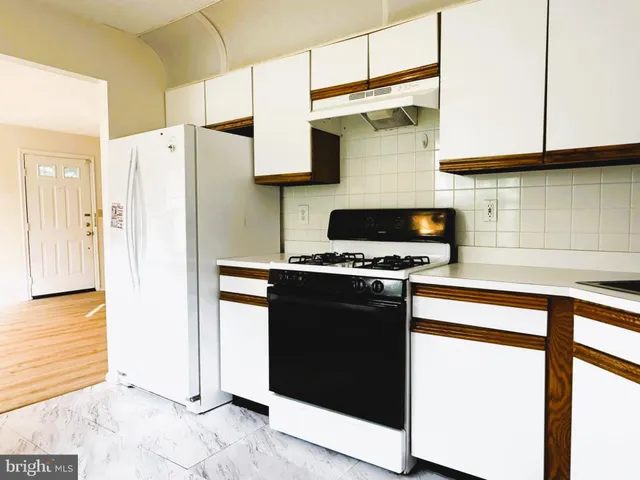 a kitchen with stainless steel appliances granite countertop a refrigerator and a stove