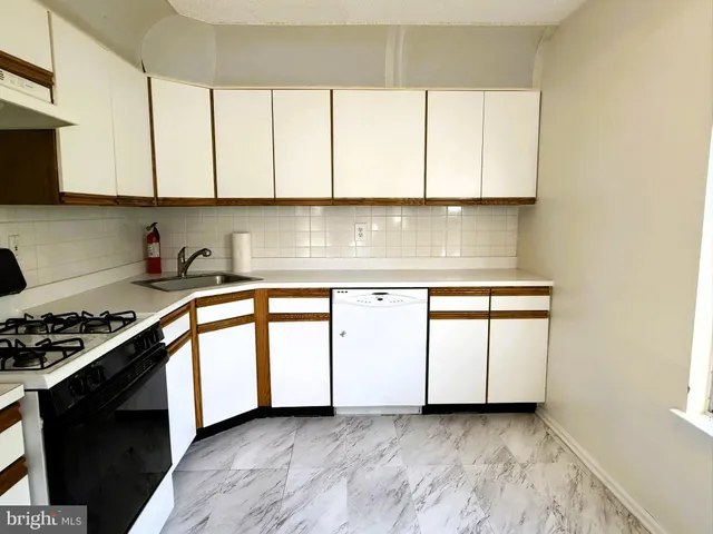 a kitchen with granite countertop white cabinets and a stove