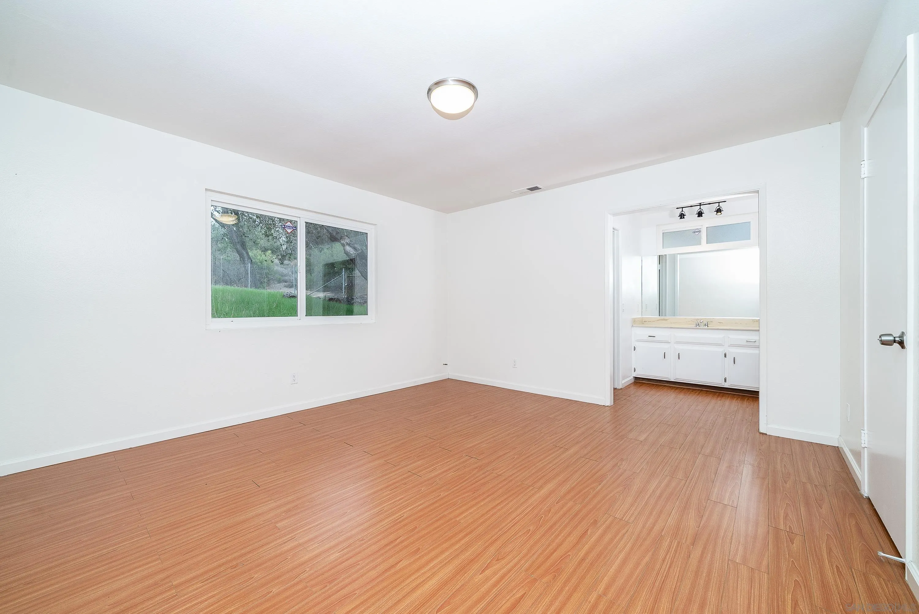 1343 Live Oak Park Road South Fallbrook, CA 92028 - Photo 25 of 55 an empty room with wooden floor and windows