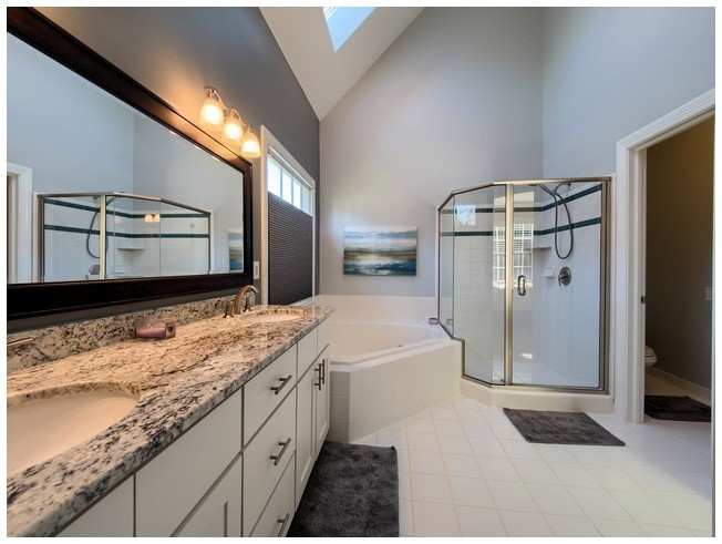8000 Kukui Court Raleigh, NC 27613 - Photo 15 of 25 Master bath updates include comfort height vanity with granite top and u/m porcelain sinks, framed mirror, brushed nickel faucets, lighting and shower surround. Master Bath/Spa
