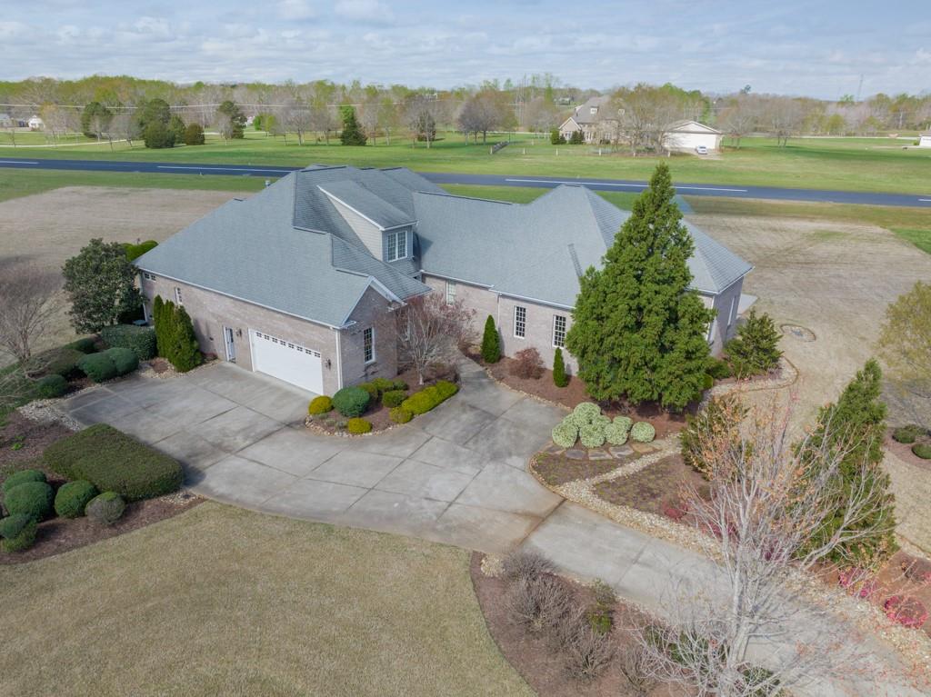 an aerial view of a house with a garden and lake view