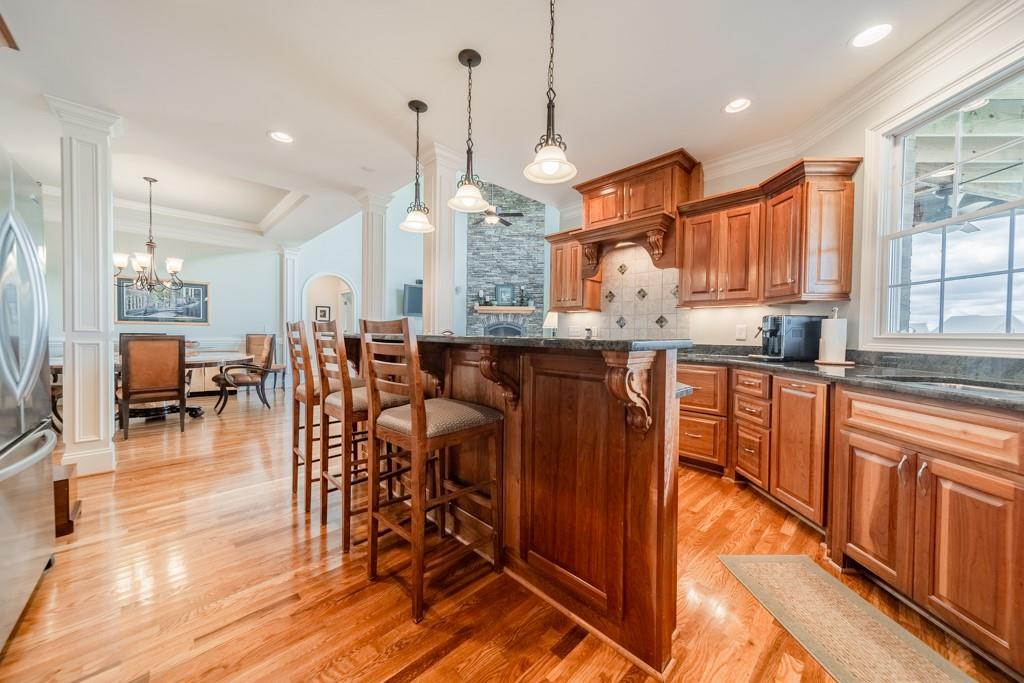 180 Chandelle Ridge Drive Woodruff, SC 29388 - Photo 24 of 48 a kitchen with stainless steel appliances granite countertop a stove top oven a sink a dining table and chairs with wooden floor