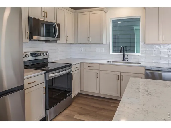 a bathroom with a granite countertop sink toilet a mirror and shower