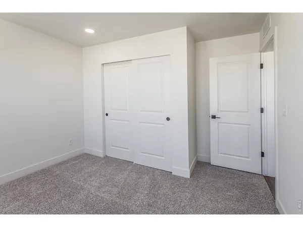 a view of an empty room with wooden floor and window