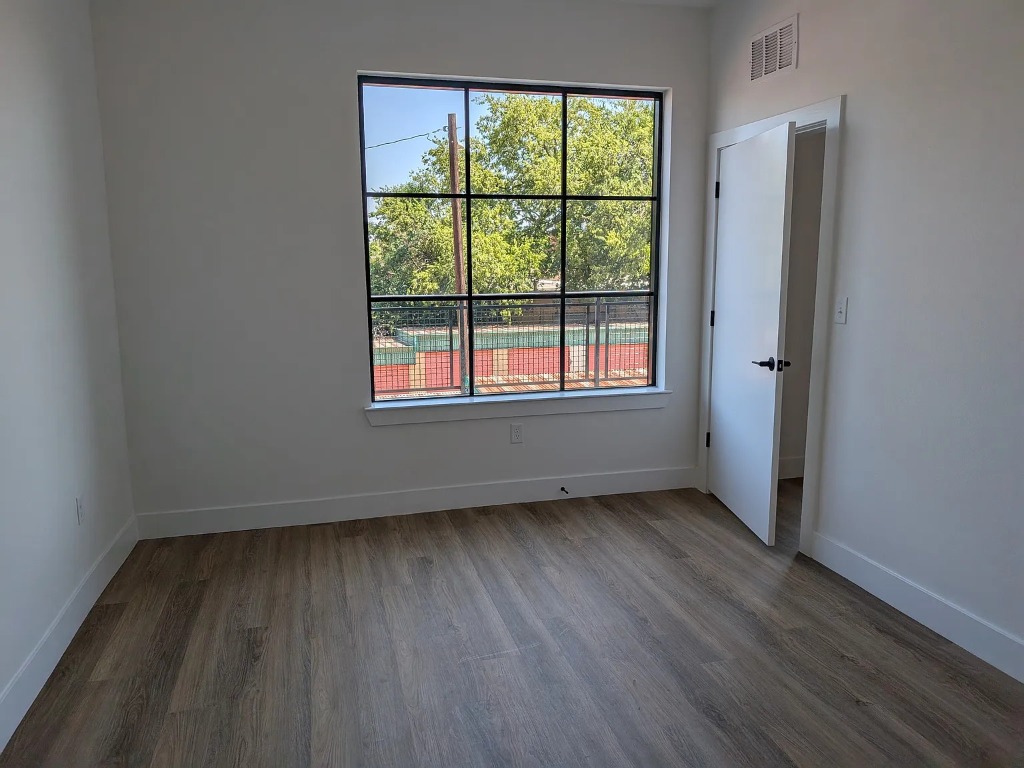 4315 South Congress Avenue, Unit 233 Austin, TX 78745 - Photo 7 of 25 an empty room with wooden floor and windows