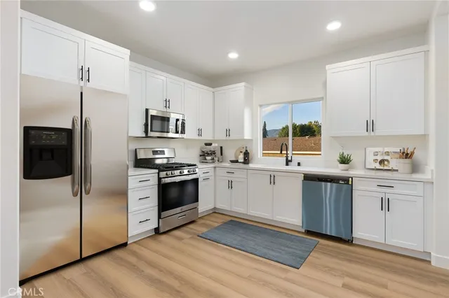 a living room with furniture a flat screen tv and kitchen view
