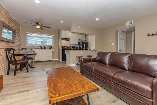 a living room with kitchen island furniture and a wooden floor
