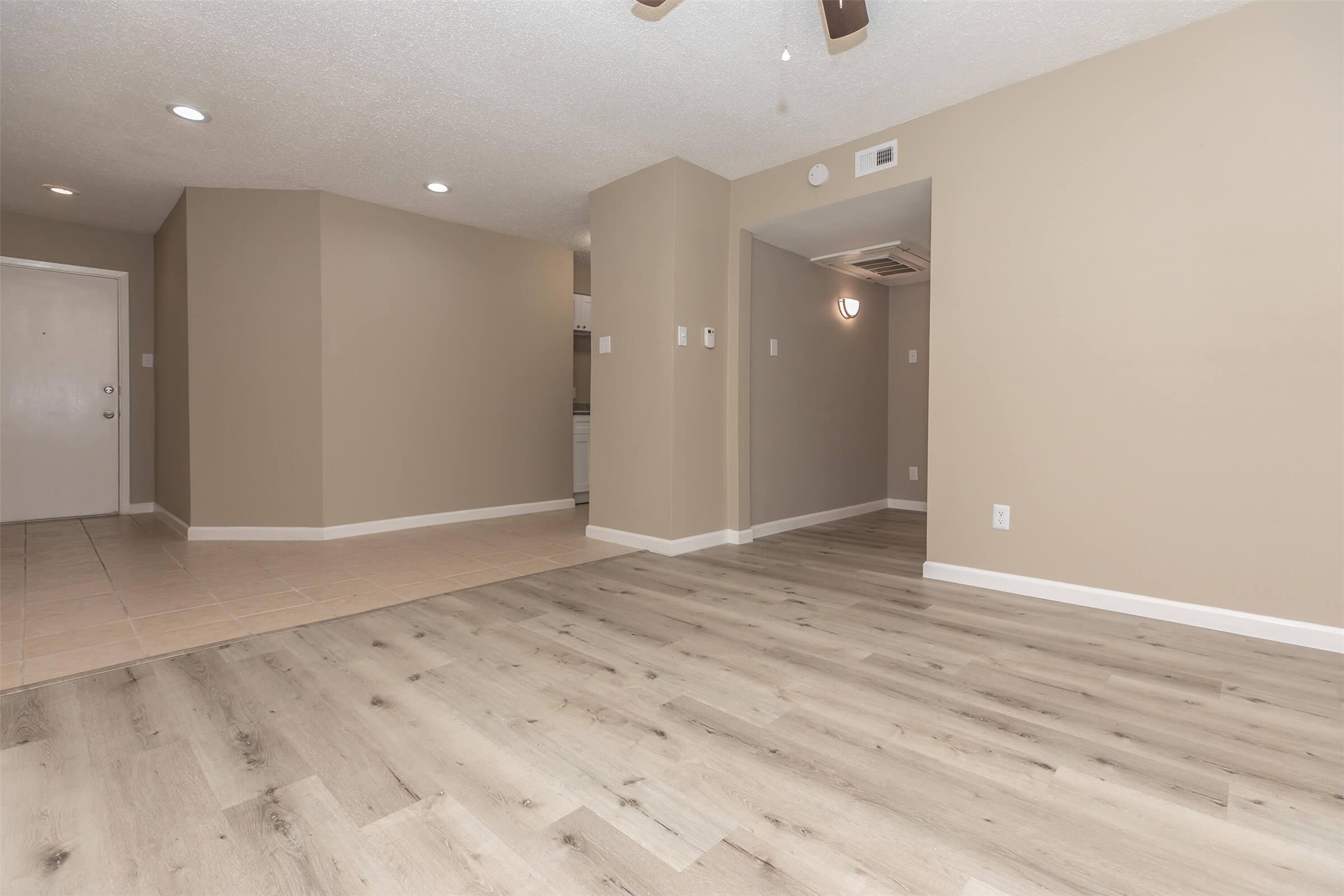 9707 Timberside Drive, Unit 2 Houston, TX 77025 - Photo 10 of 16 an empty room with wooden floor and mirror