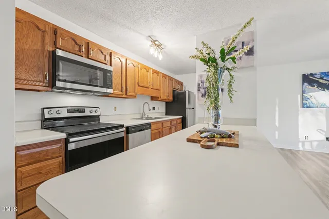 a kitchen with stainless steel appliances a stove a sink and a microwave