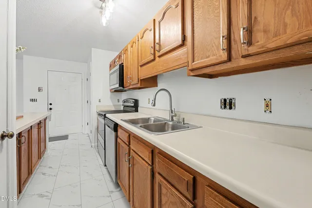 a kitchen with stainless steel appliances granite countertop a sink and dishwasher a stove top oven with wooden floor