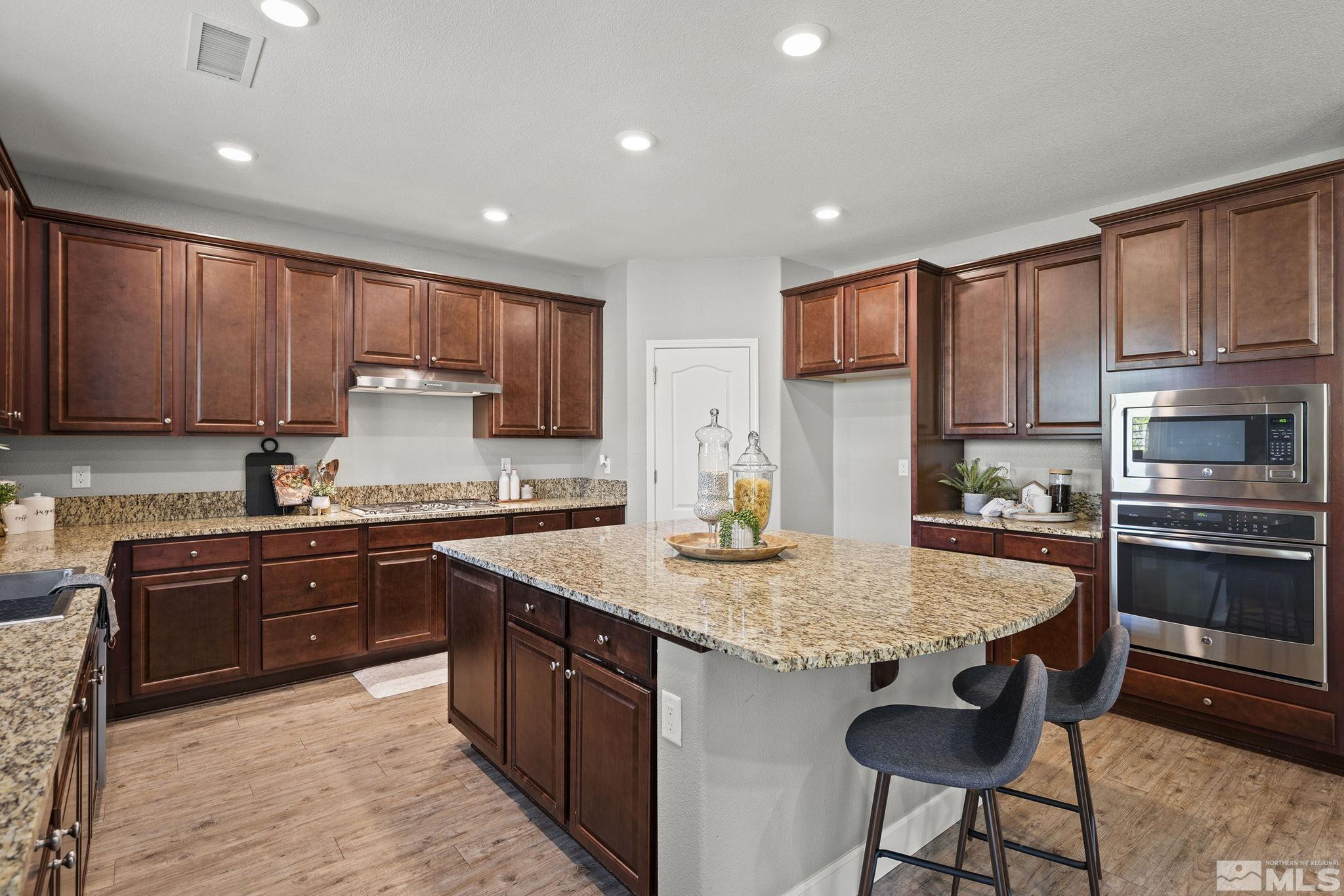 1820 Scott Valley Road Reno, NV 89523 - Photo 11 of 35 a kitchen with kitchen island granite countertop wooden cabinets a stove a sink and stainless steel appliances