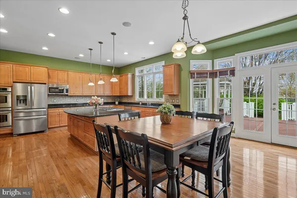 a kitchen with stainless steel appliances granite countertop a sink a stove and a refrigerator
