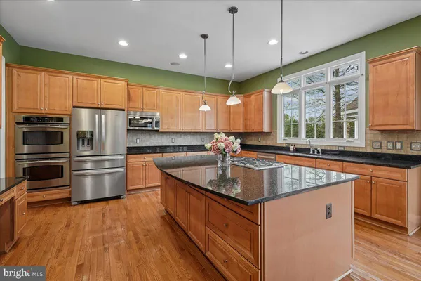 a kitchen with stainless steel appliances granite countertop a stove and a refrigerator