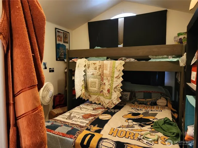 a bed sitting in a bedroom next to a window with tv