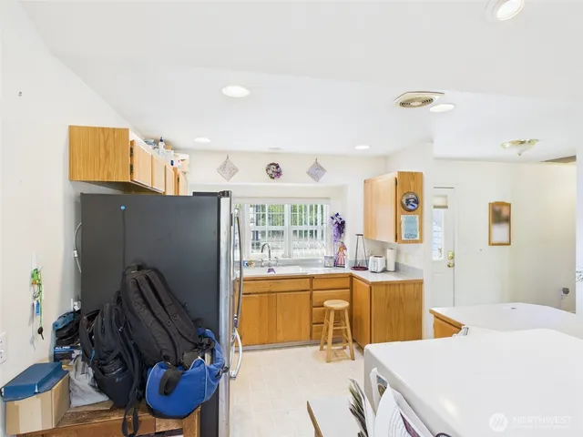 a view of a kitchen with kitchen island stainless steel appliances wooden floor and cabinets