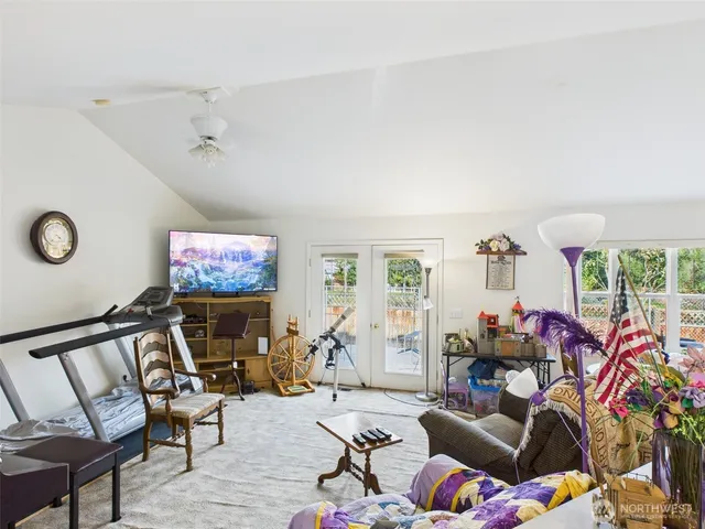 a living room with furniture a flat screen tv and a large window