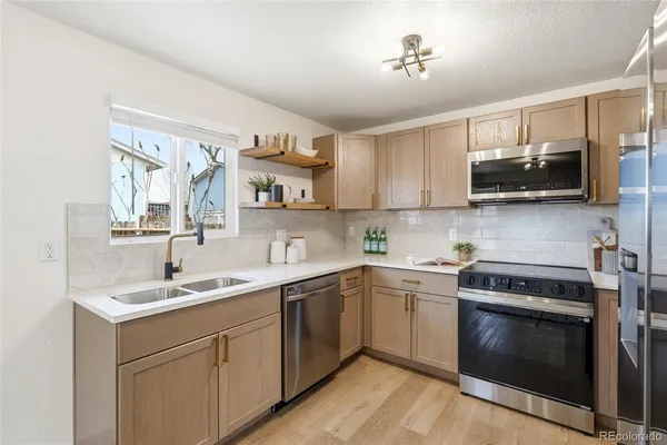 a kitchen with stainless steel appliances a stove sink microwave and cabinets