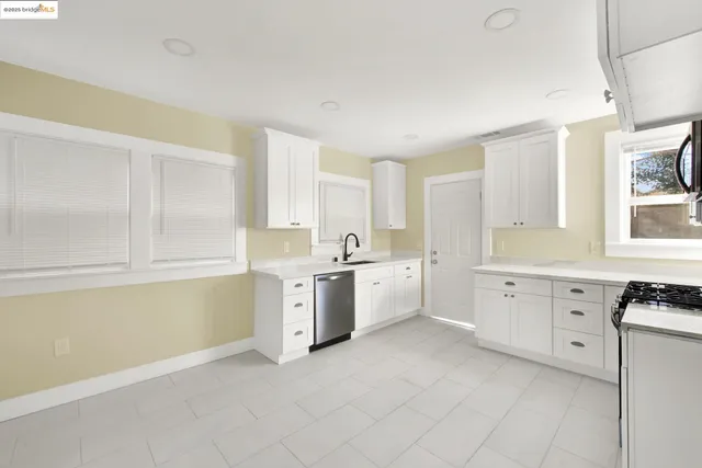a large white kitchen with cabinets