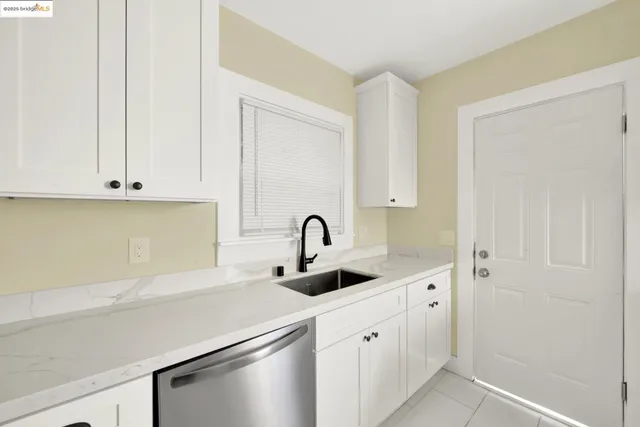 a kitchen with white cabinets and a sink