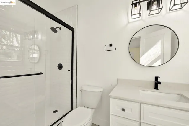 a bathroom with a sink a mirror a toilet and a shower