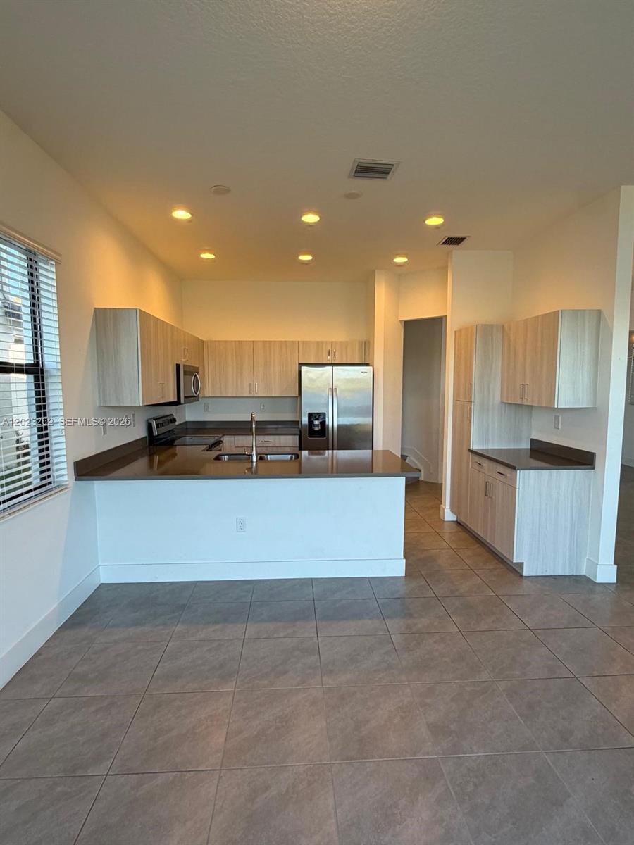5669 Cerva Lane, Unit 5669 Immokalee, FL 34142 - Photo 5 of 32 a large kitchen with stainless steel appliances lots of counter top space