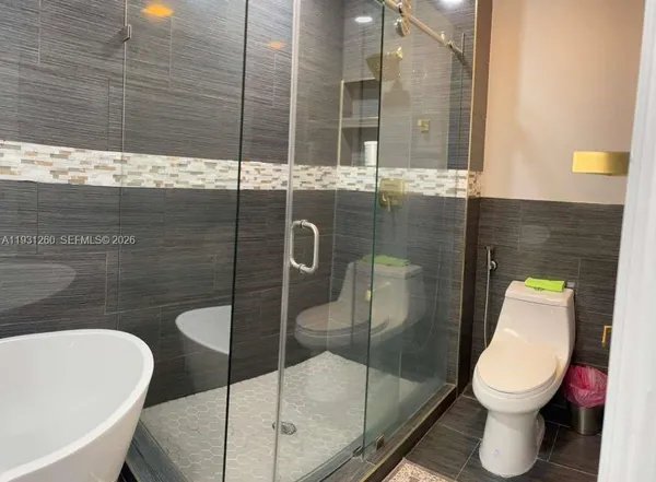 a bedroom with a large bed and a shower