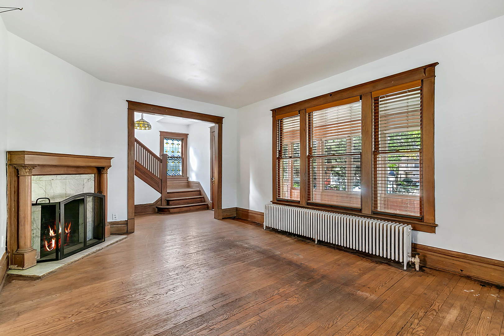 99 Pine Avenue Riverside, IL 60546 - Photo 3 of 31 a view of an empty room with wooden floor fireplace and a window