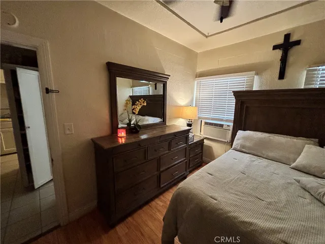 a bedroom with a bed and a mirror on the dresser
