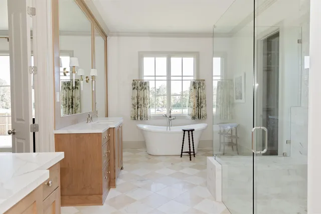 a spacious bathroom with a tub sink and mirror