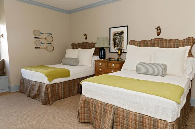 a spacious bedroom with two beds and painting on the wall