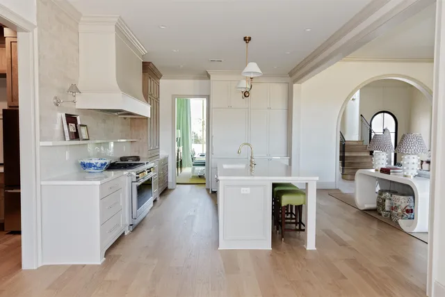 a large kitchen with stainless steel appliances a stove a sink a refrigerator and cabinets