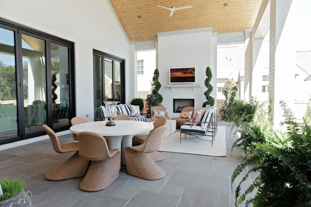 a living room with patio furniture and a potted plant