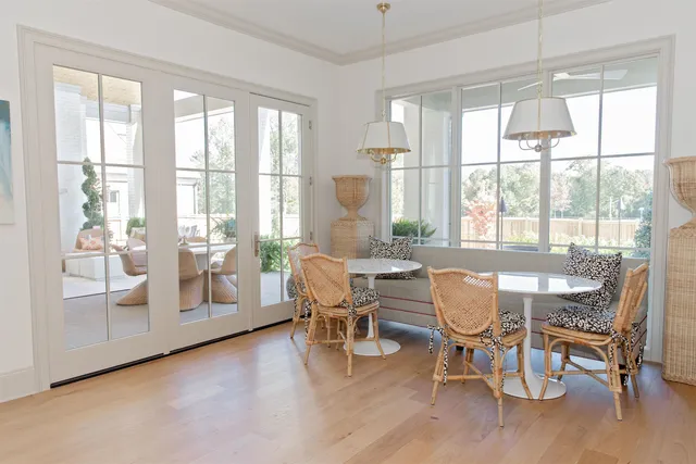 a dining room with wooden floor and large windows