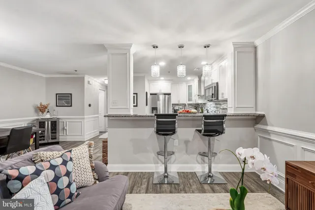 a dining hall with stainless steel appliances kitchen island granite countertop a dining table and chairs
