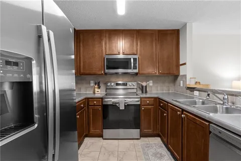 a kitchen with stainless steel appliances granite countertop a sink stove and refrigerator