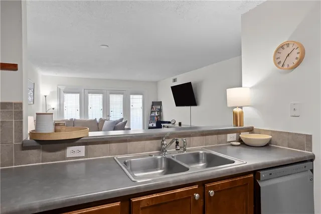 a kitchen with a sink and a clock on the wall