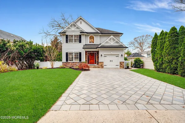 a front view of a house with a yard and potted plants